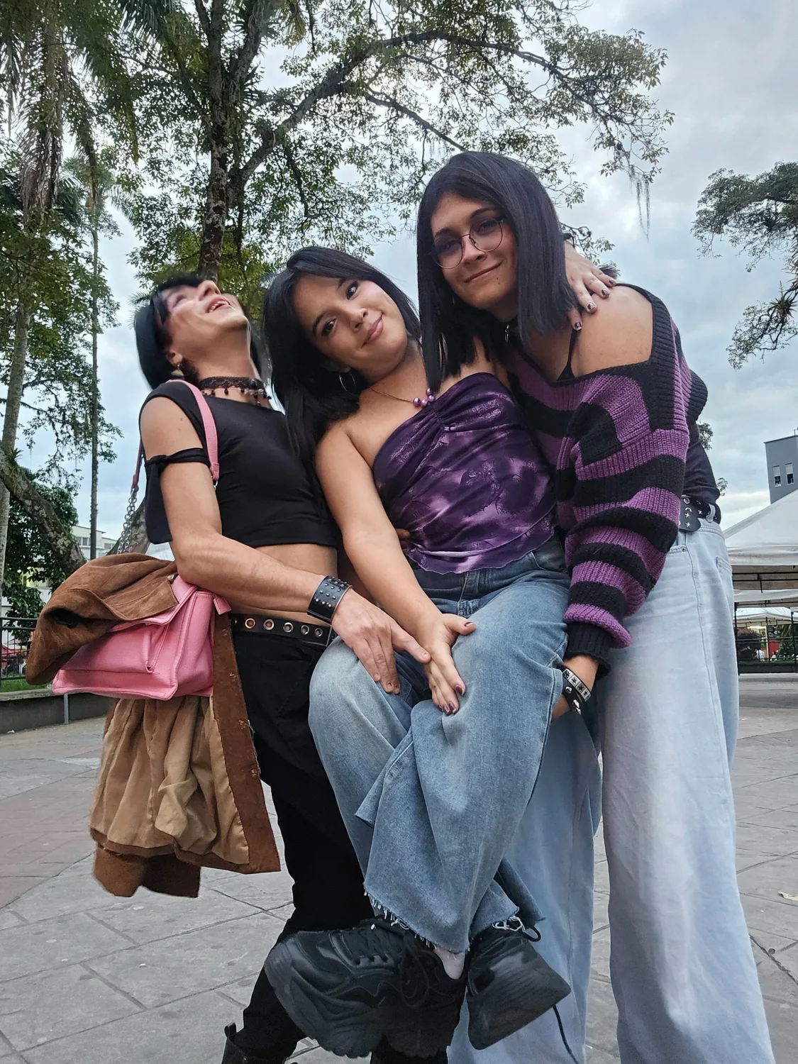 Tres integrantes de la colectiva reunides en una plaza